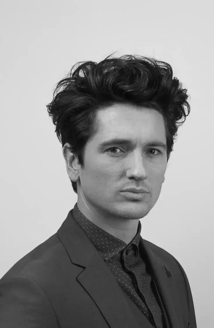 Man with brown quiff in black and white
