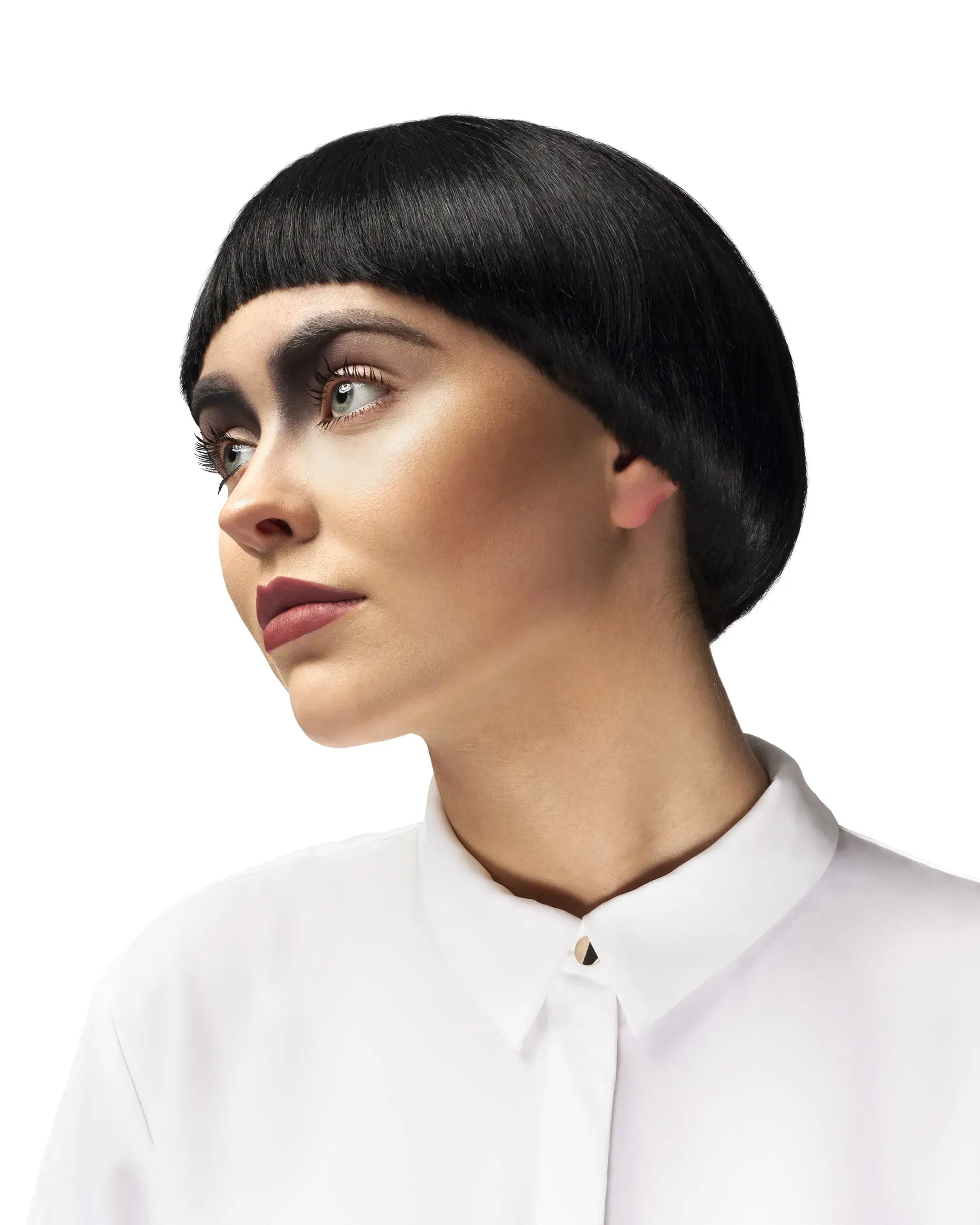 Woman with black hair in bowl cut style looking left